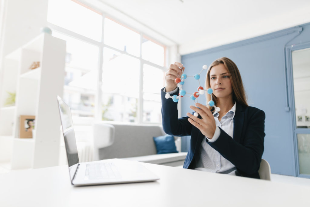 Female scientist studying molecule model