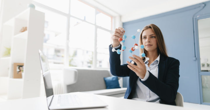 Female scientist studying molecule model